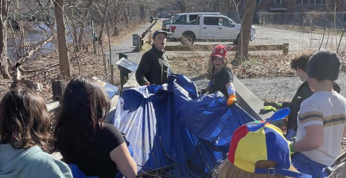 Students yanked large sticks and branches from the compost pile and put them on a large tarp. It took the entire group to transport the tarp to the riverbank area.