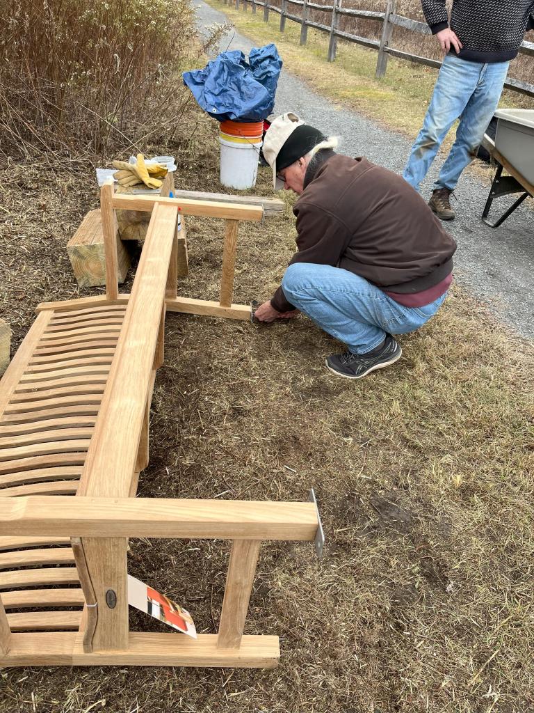 Volunteers installed hardware to secure benches to footings.