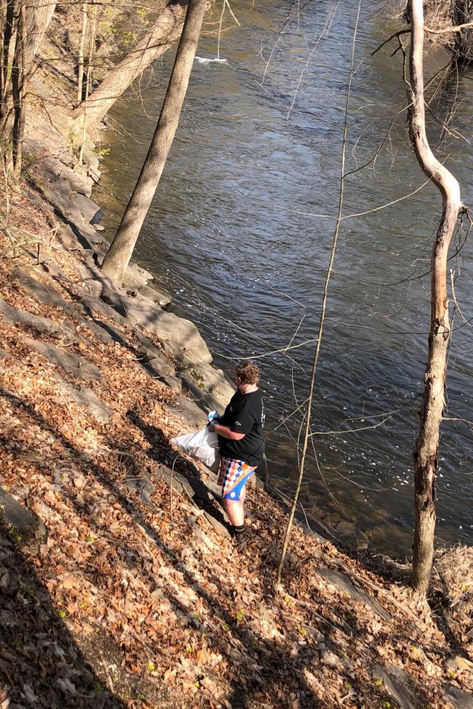 The Scout project Leader, Eli Smith, carefully scours the bank for litter. Access to this bank is only allowed with careful monitoring by the River Walk team.